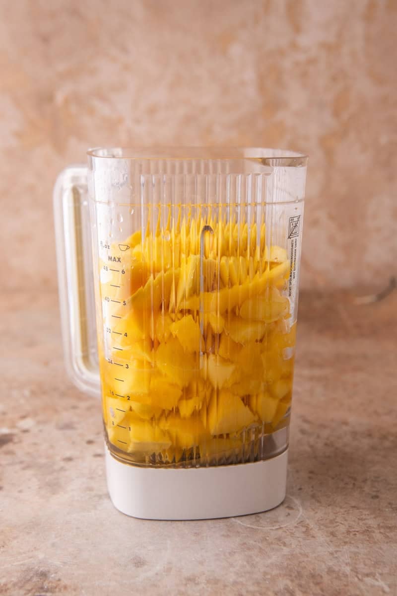 Cubed fresh mango in a blender jar.