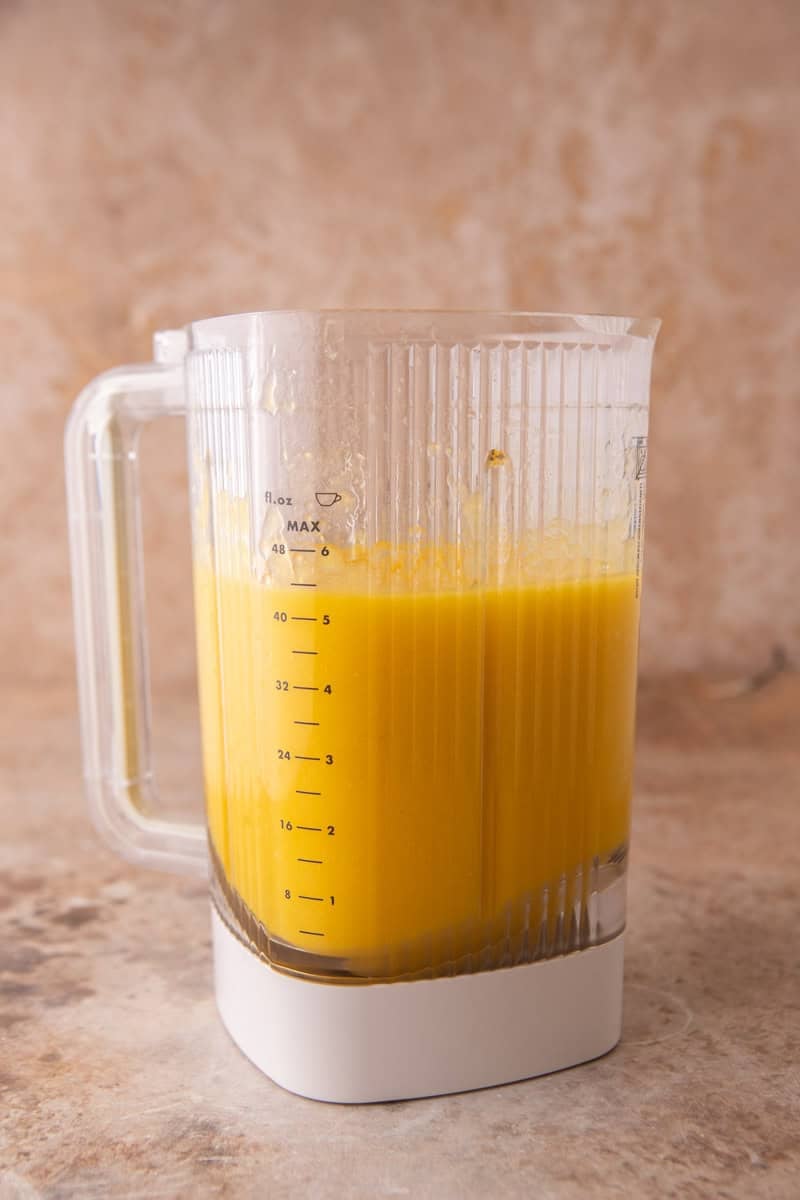Silky, pourable mango sorbet base in a blender jar.