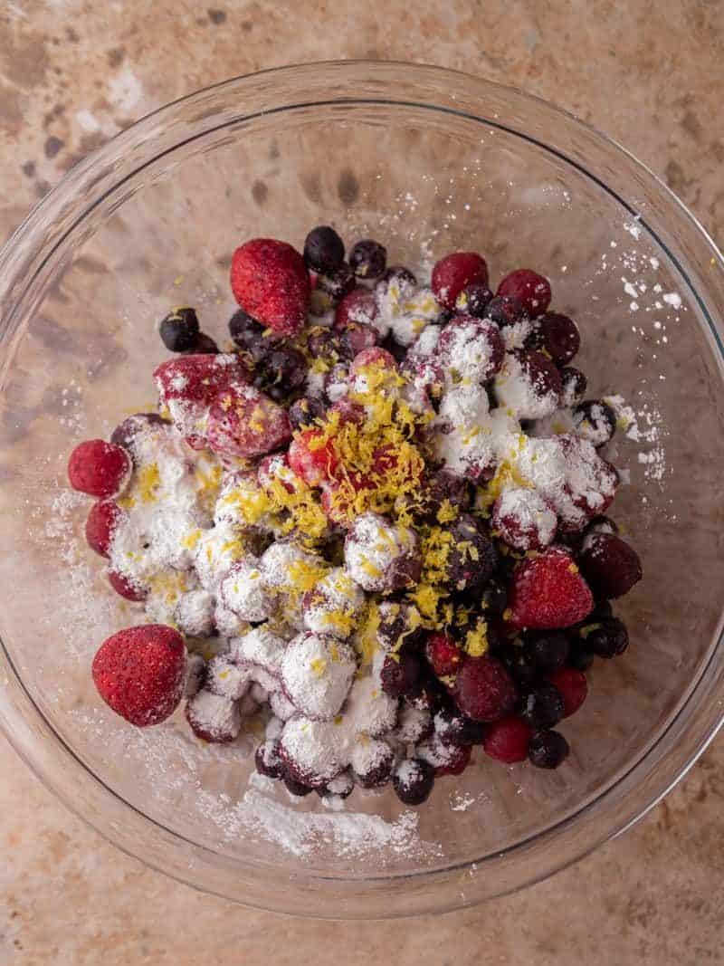 Frozen mixed berries in a bowl before adding sugar and cornstarch for the cobbler filling