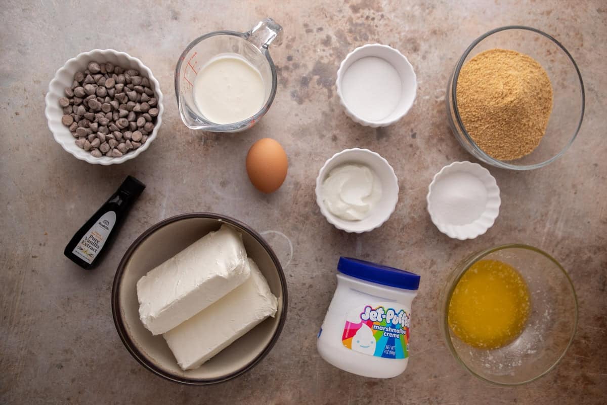 Ingredients including cream cheese, marshmallow fluff, graham crumbs, chocolate, sugar, sour cream, butter, and an egg