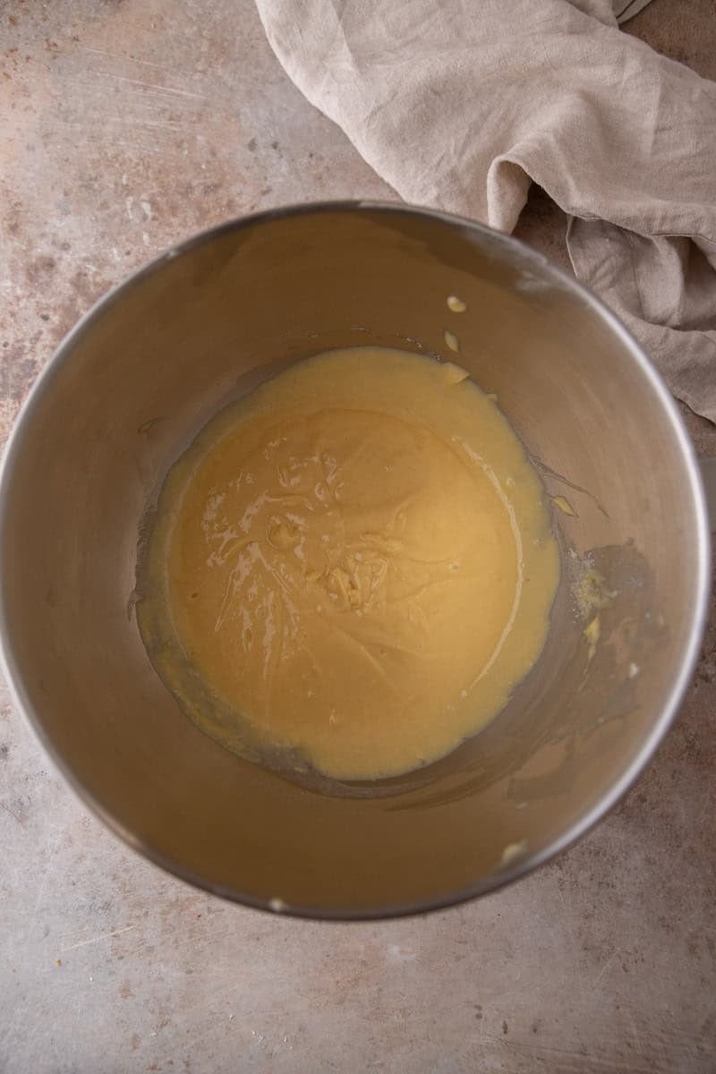 : Smooth vanilla cake batter in a stainless steel mixing bowl
