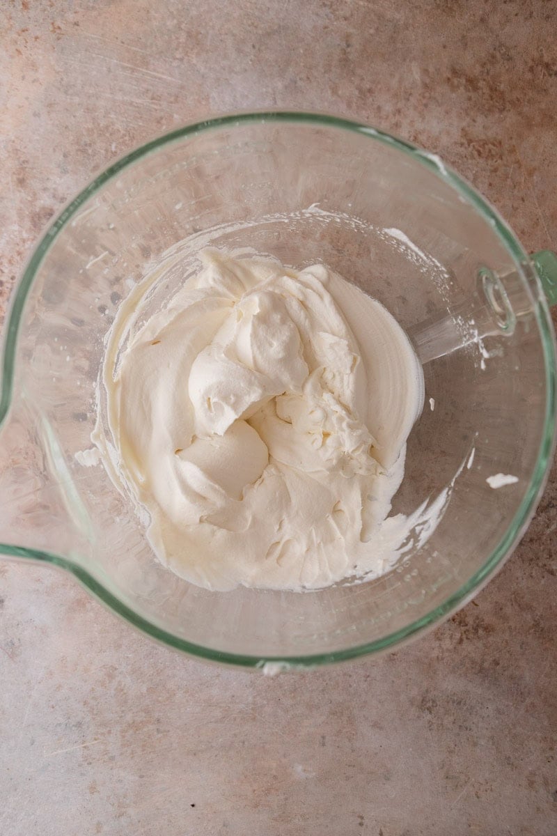 Heavy cream whipped to medium-stiff peaks in a glass measuring cup for the chocolate mousse