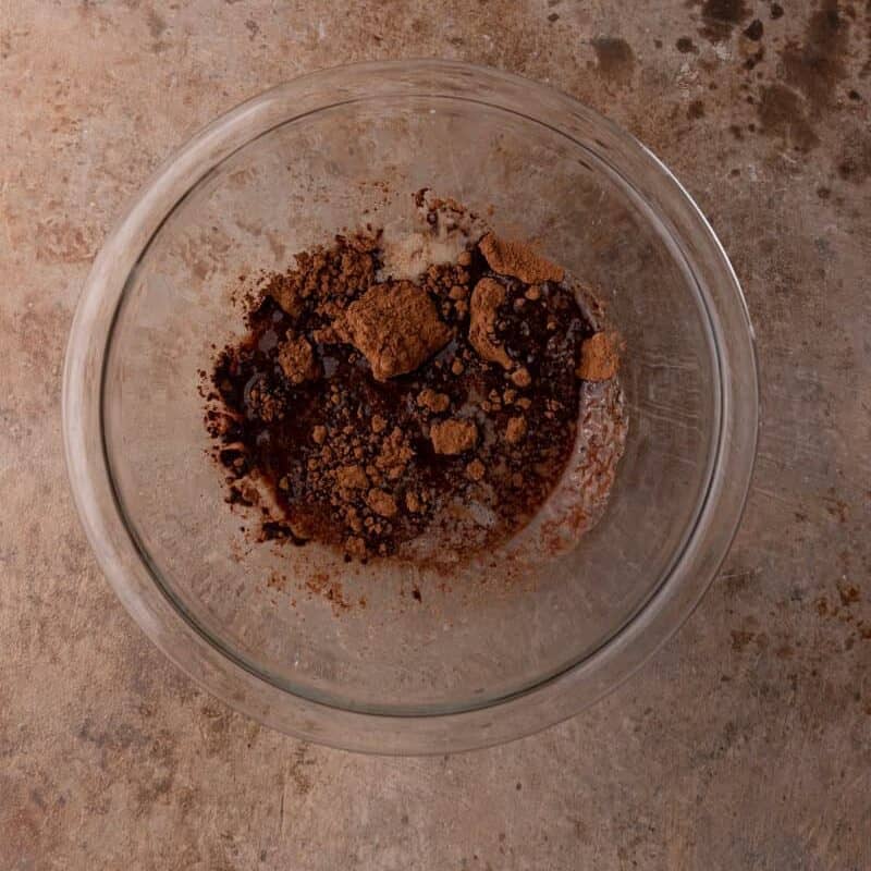 the butter and cocoa powder of the brownie frosting recipe melted together in a bowl