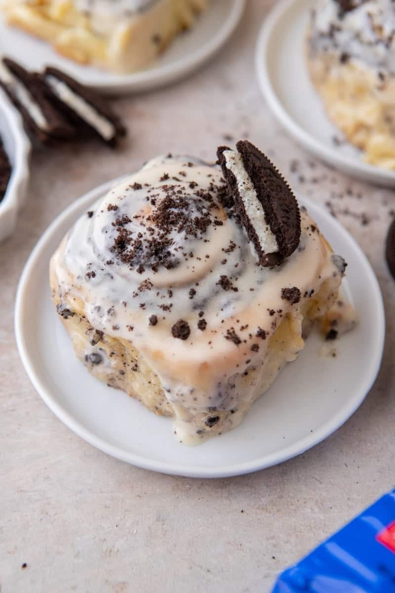 Oreo cinnamon roll topped with cream cheese glaze, crushed Oreos, and a half Oreo cooki