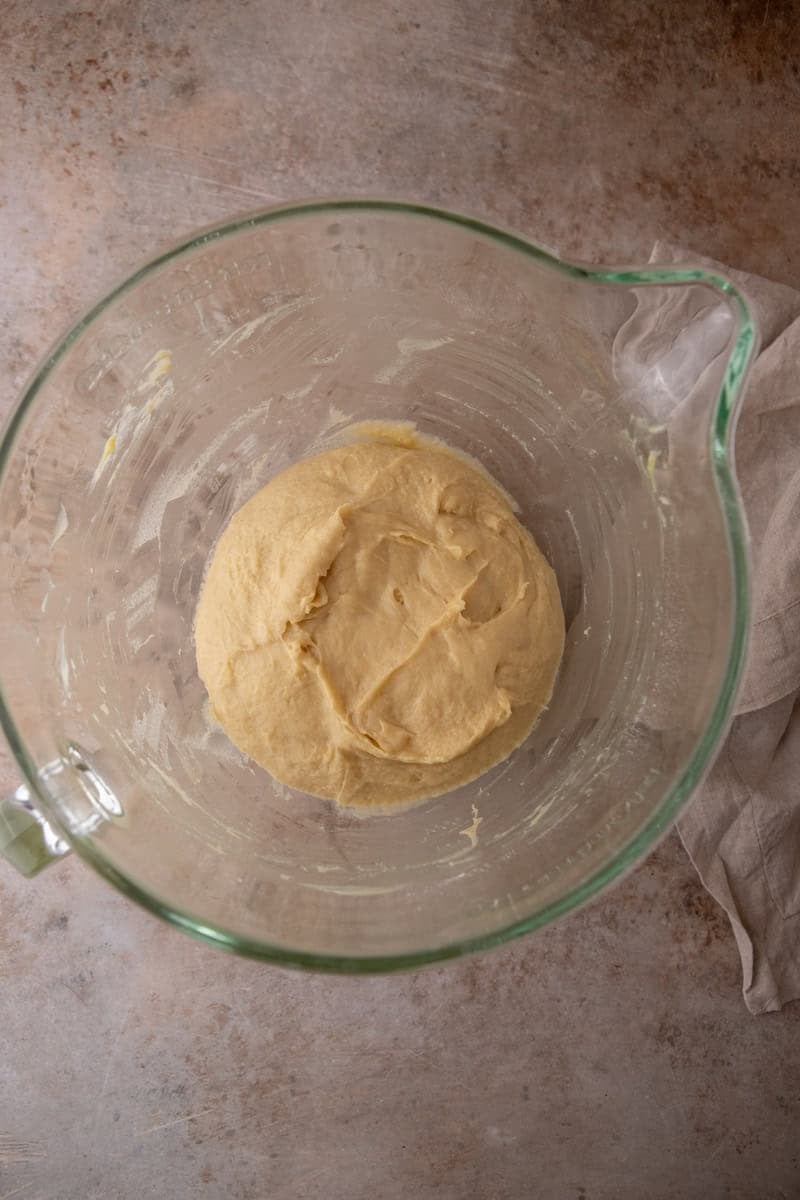 Soft brioche dough ball in a glass bowl before the first rise