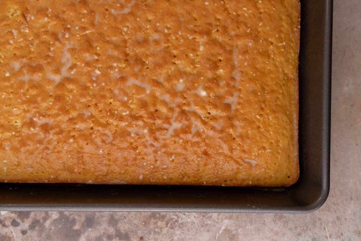 Close up of baked tres leches cake sponge showing golden textured top