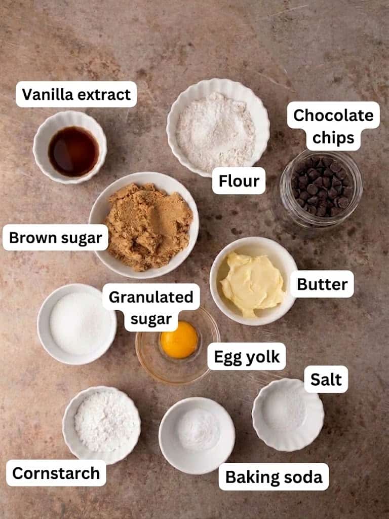 Butter, brown sugar, flour, cornstarch, one egg yolk, and chocolate chips measured into small bowls.