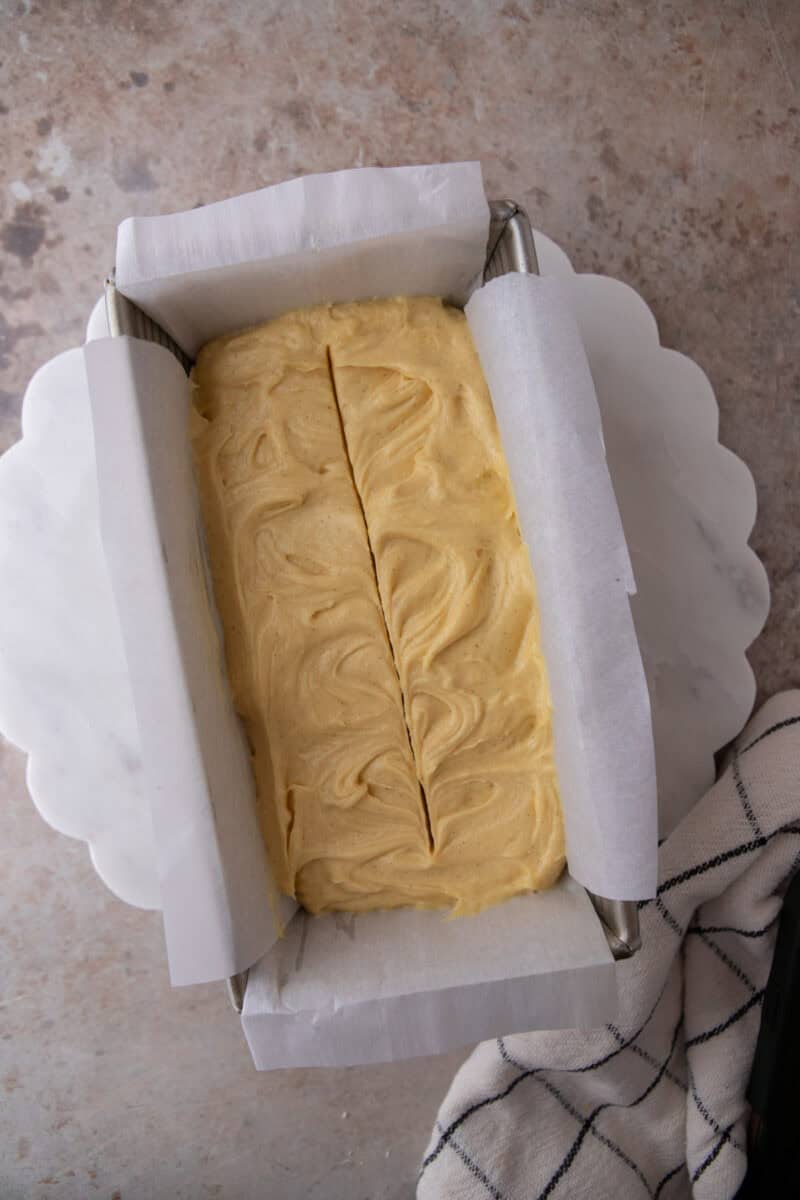 Honey tea cake batter smoothed into a buttered and floured loaf pan before baking.