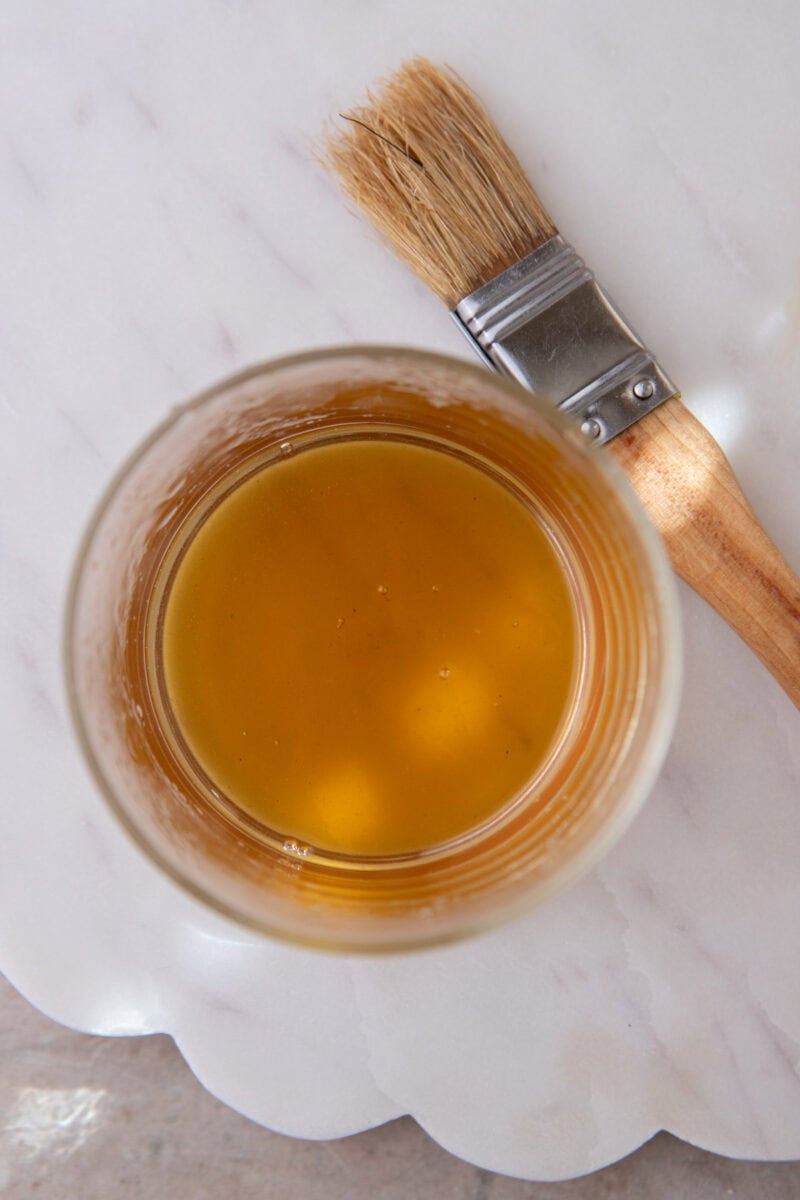 Honey and hot water whisked into a smooth pourable syrup in a small measuring cup.