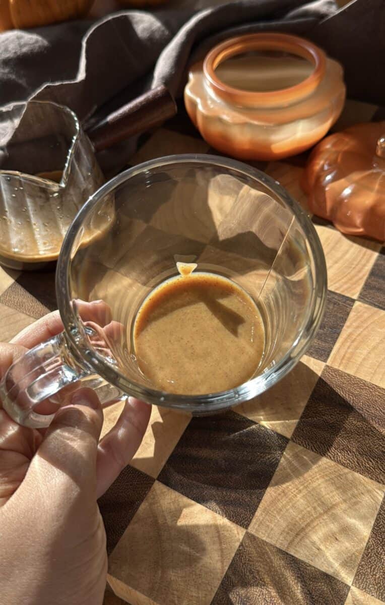 Pumpkin spice sauce in a tall glass mug.