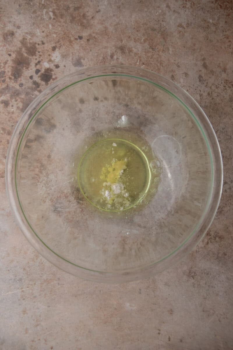 Two fresh egg whites in a clean glass bowl, ready to whip into meringue.