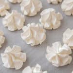 Baked crispy vanilla meringue cookies on a baking sheet.