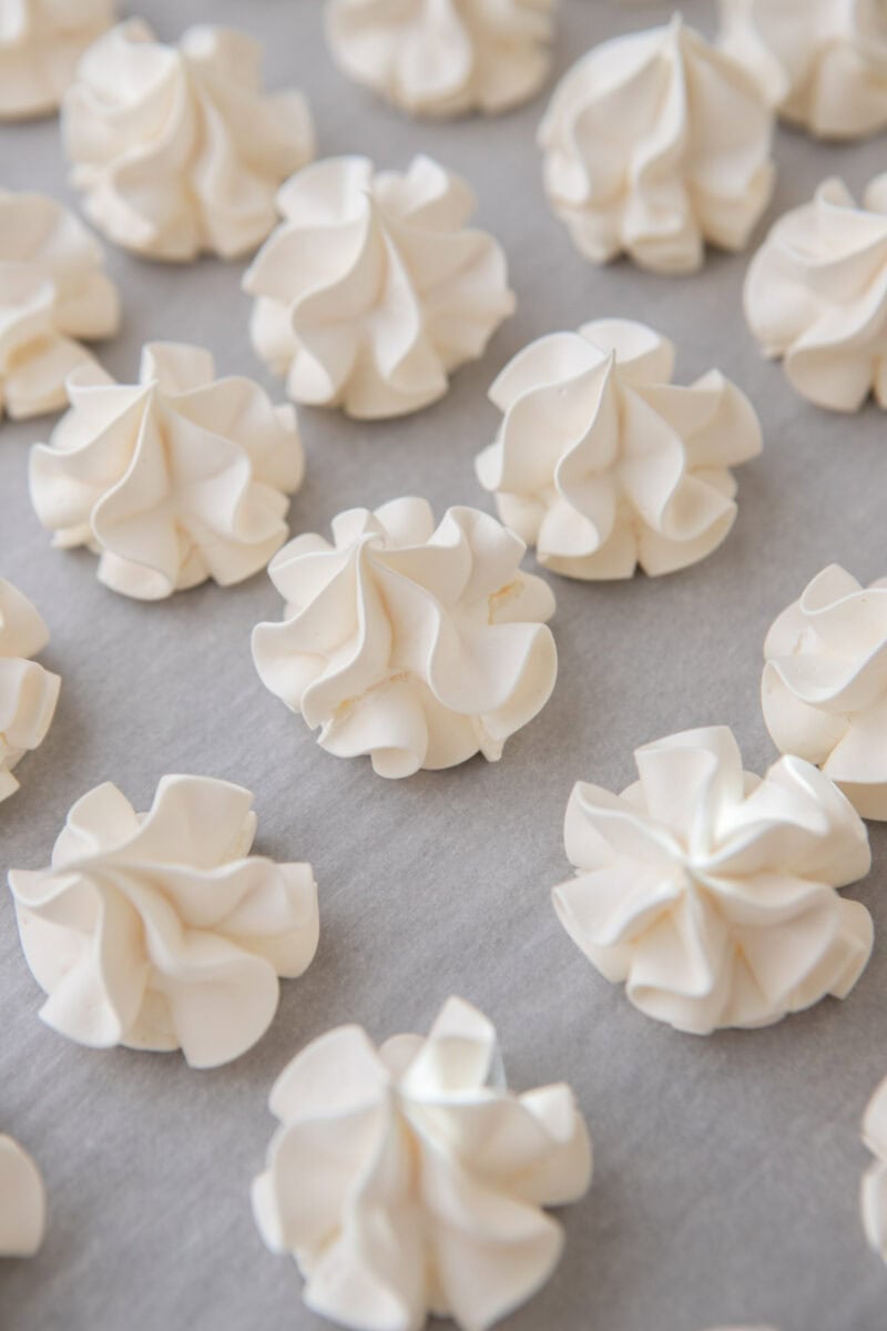Baked crispy vanilla meringue cookies on a baking sheet.