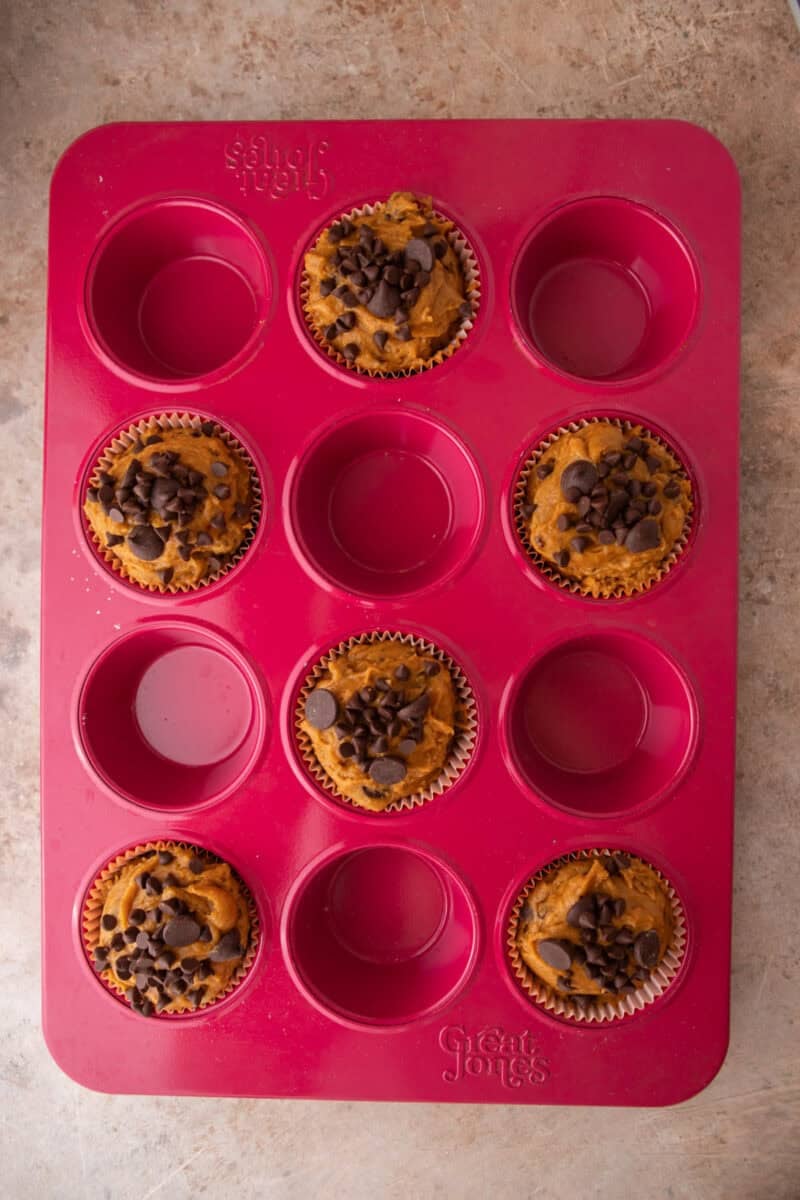Staggered muffin pan with alternating cavities filled to the rim and topped with chips.