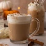 Copycat Starbucks pumpkin spice latte in a glass mug with whipped cream and spice dusting.