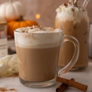 Copycat Starbucks pumpkin spice latte in a glass mug with whipped cream and spice dusting.