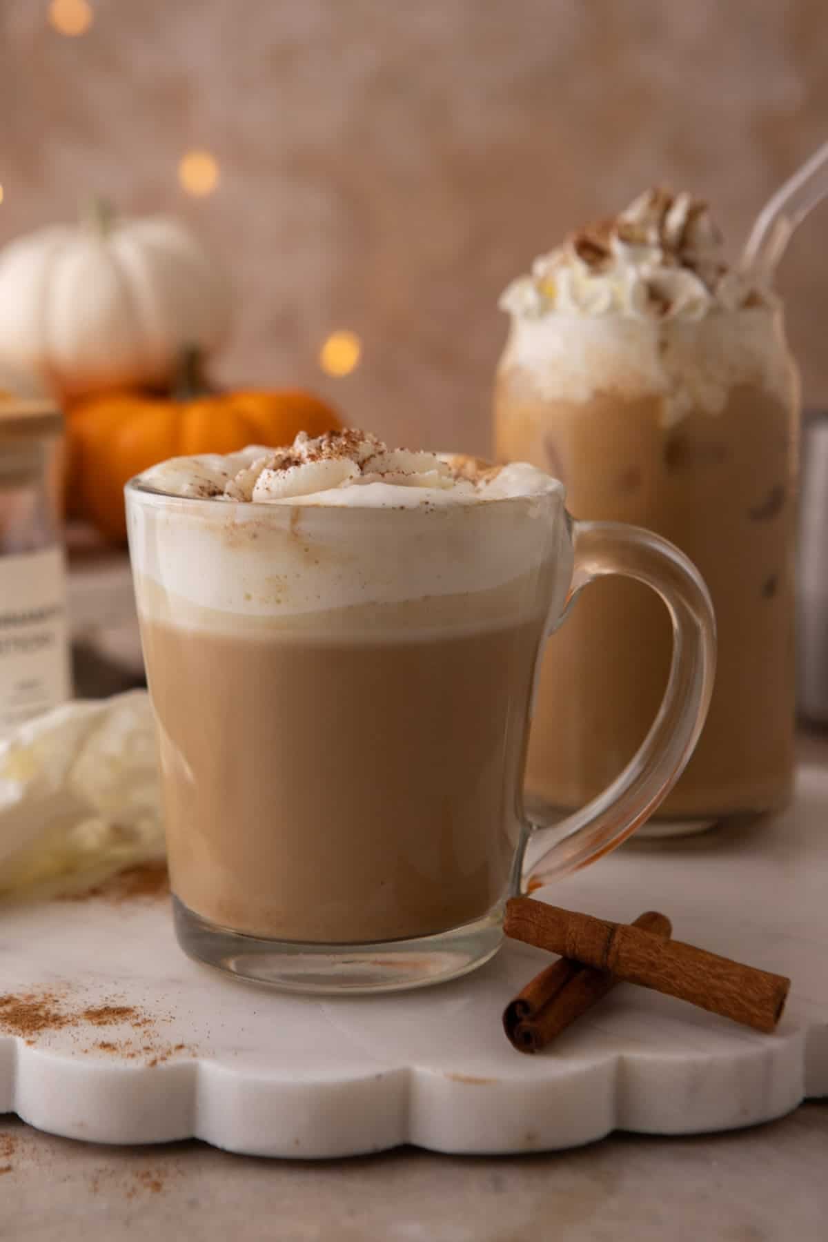 Copycat Starbucks pumpkin spice latte in a glass mug with whipped cream and spice dusting.